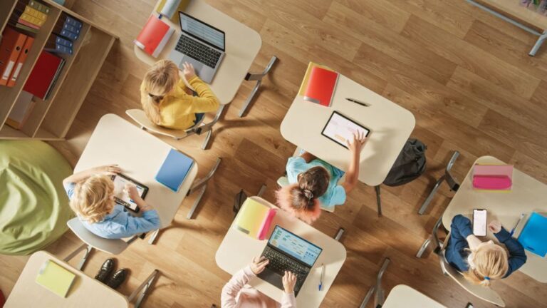 Classroom: Children Sitting at their School Desk Using Personal Computers and Digital Tablets for Assignments.